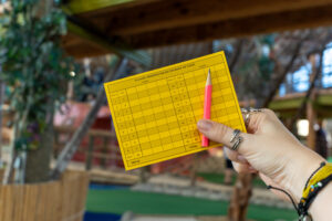a person holding a yellow piece of paper with a pencil in it