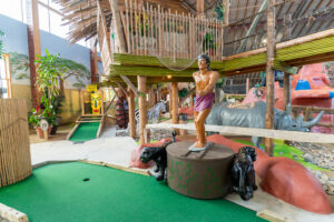 a miniature golf course with a statue of a man