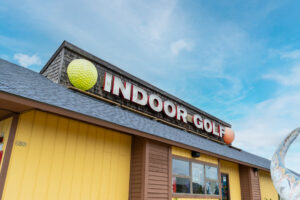 a yellow building with a sign that says indoor golf