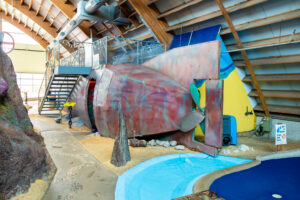 a water slide inside of a building next to a swimming pool