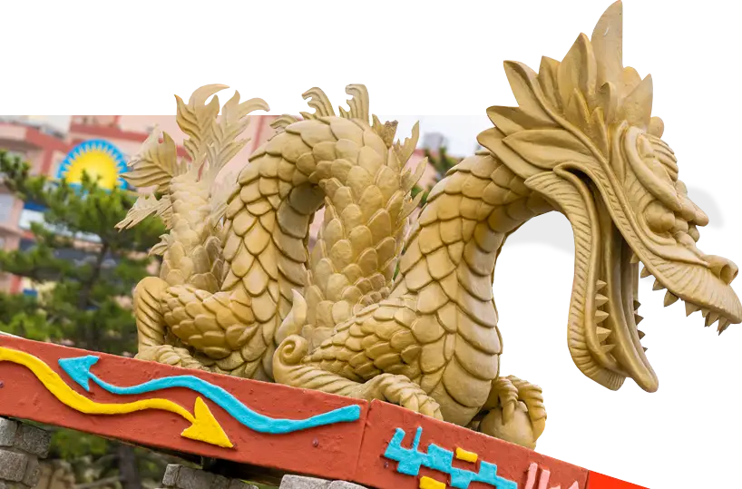 a dragon statue on top of a sign