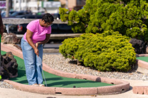 a woman playing mini golf in a miniature golf course
