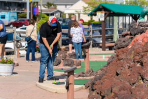 a group of people playing miniature golf in a miniature golf course