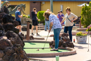 a group of people playing mini golf in a miniature golf course