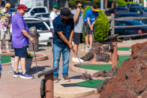 a group of people standing around a miniature golf course