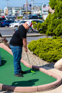 a man playing mini golf in a parking lot