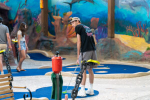a group of people standing around a miniature golf course