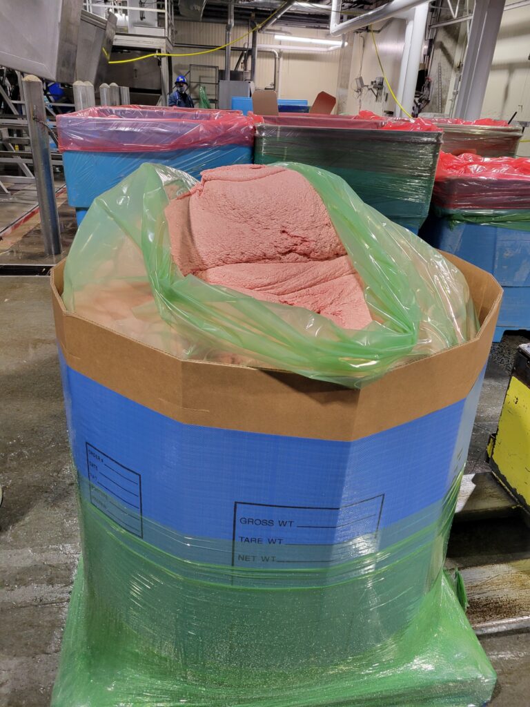 Cardboard bin filled with pink substance