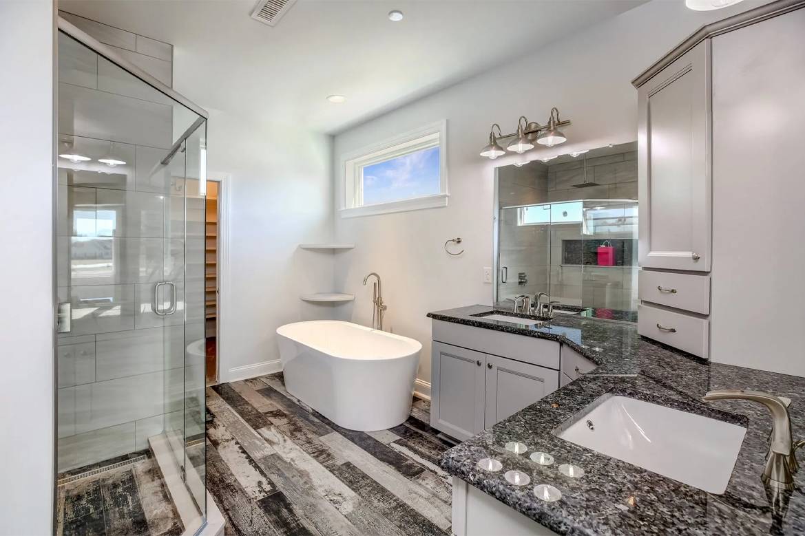 a bathroom with a tub, sink, and shower