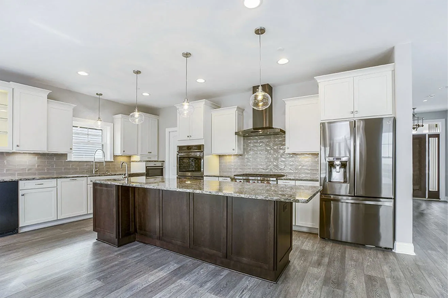 a large kitchen with a center island and stainless steel appliances