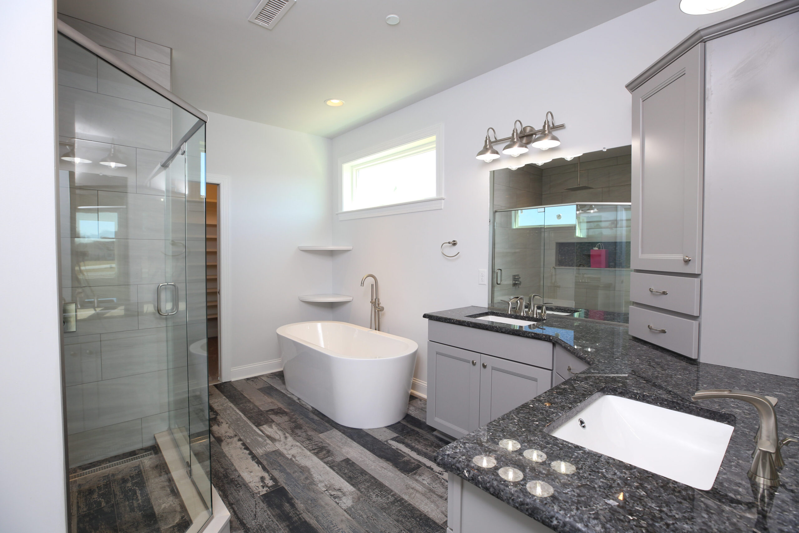 a large bathroom with a walk in shower next to a sink