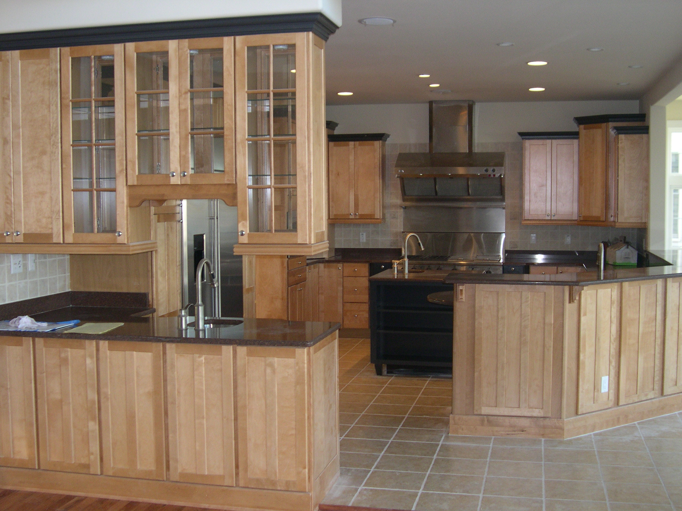 a large kitchen with wooden cabinets and tile flooring