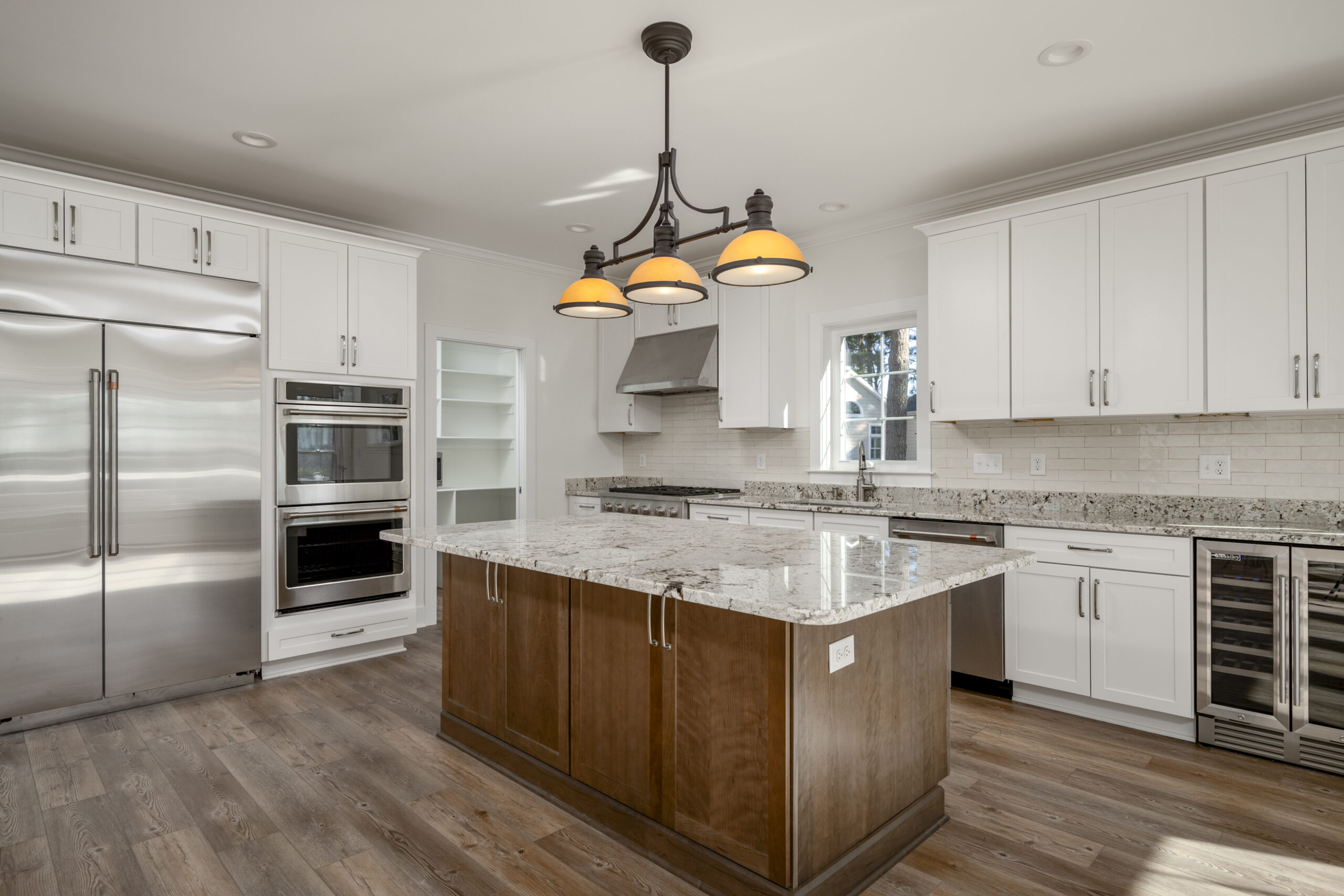 a large kitchen with white cabinets and stainless steel appliances