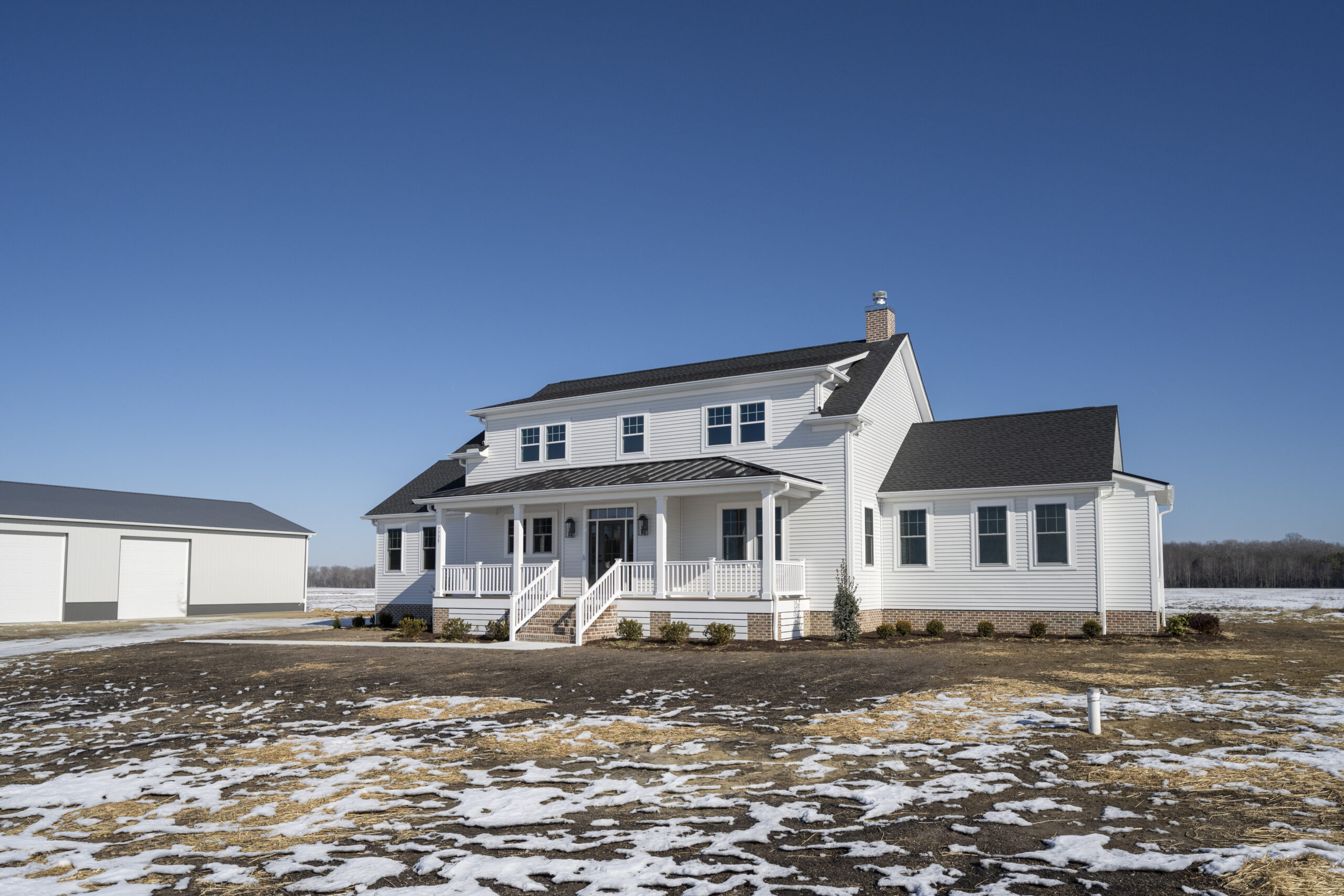 a large white house sitting on top of a snow covered field