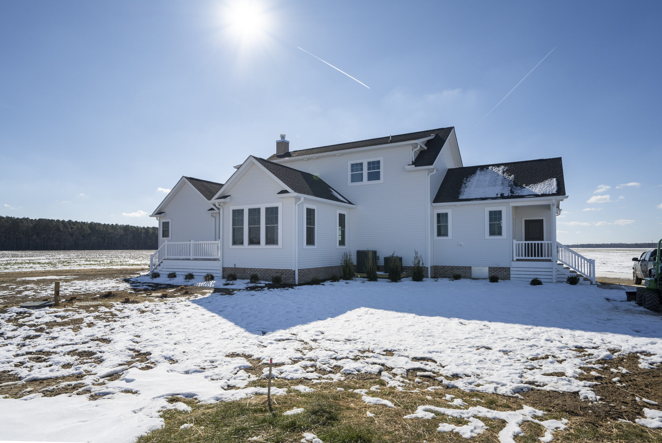a large white house sitting on top of a snow covered field
