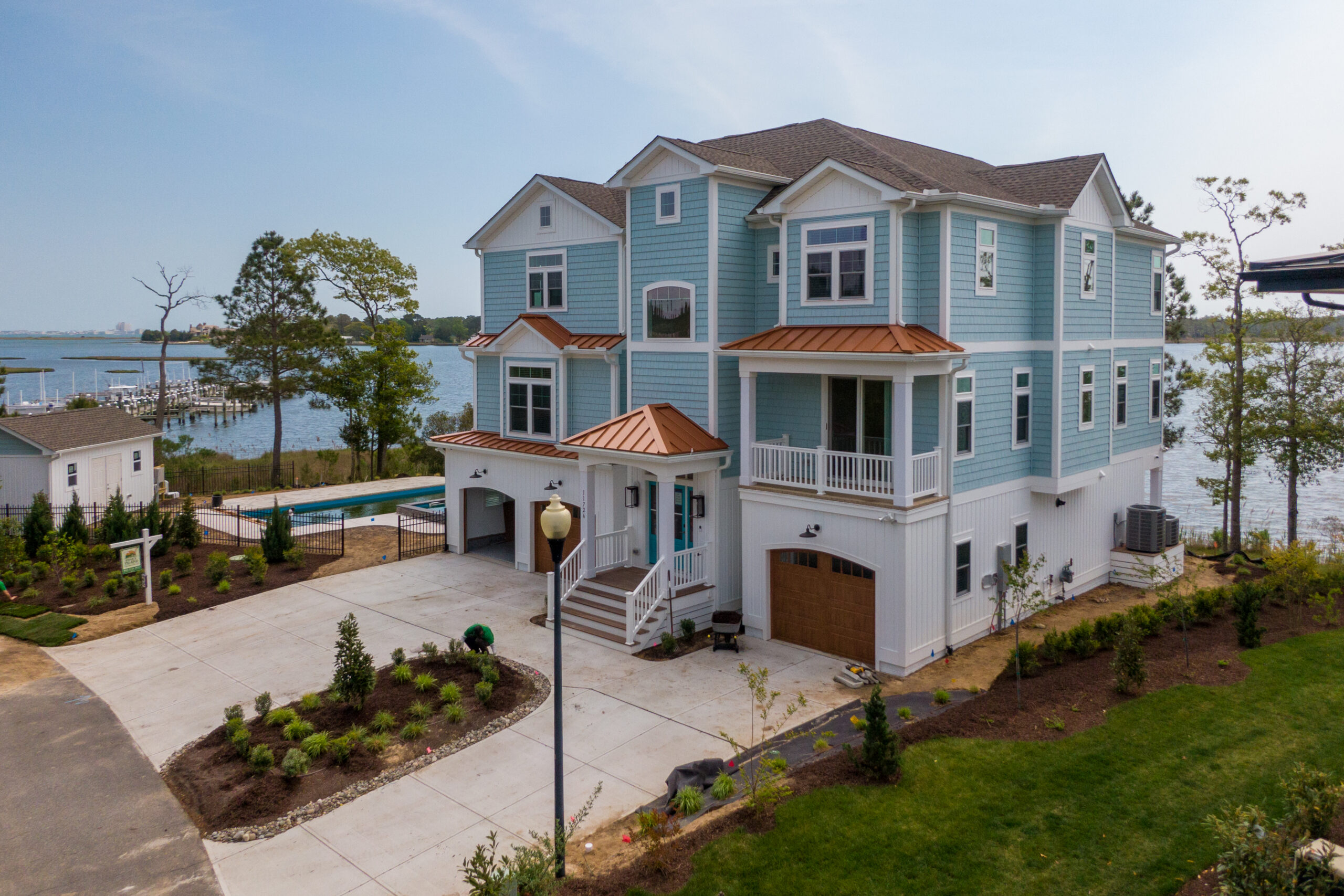 a large blue and white house next to a body of water