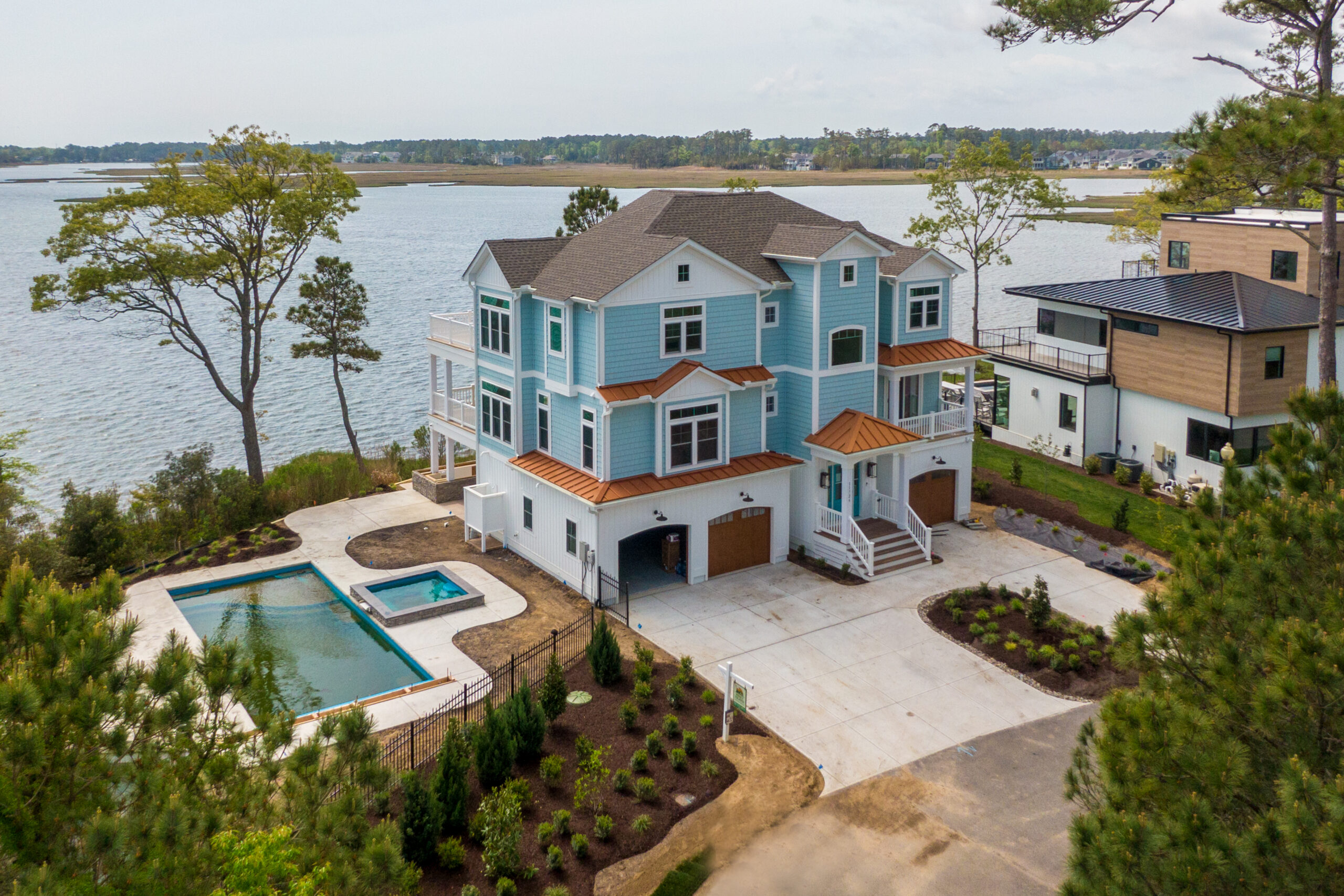 an aerial view of a house with a pool in the foreground