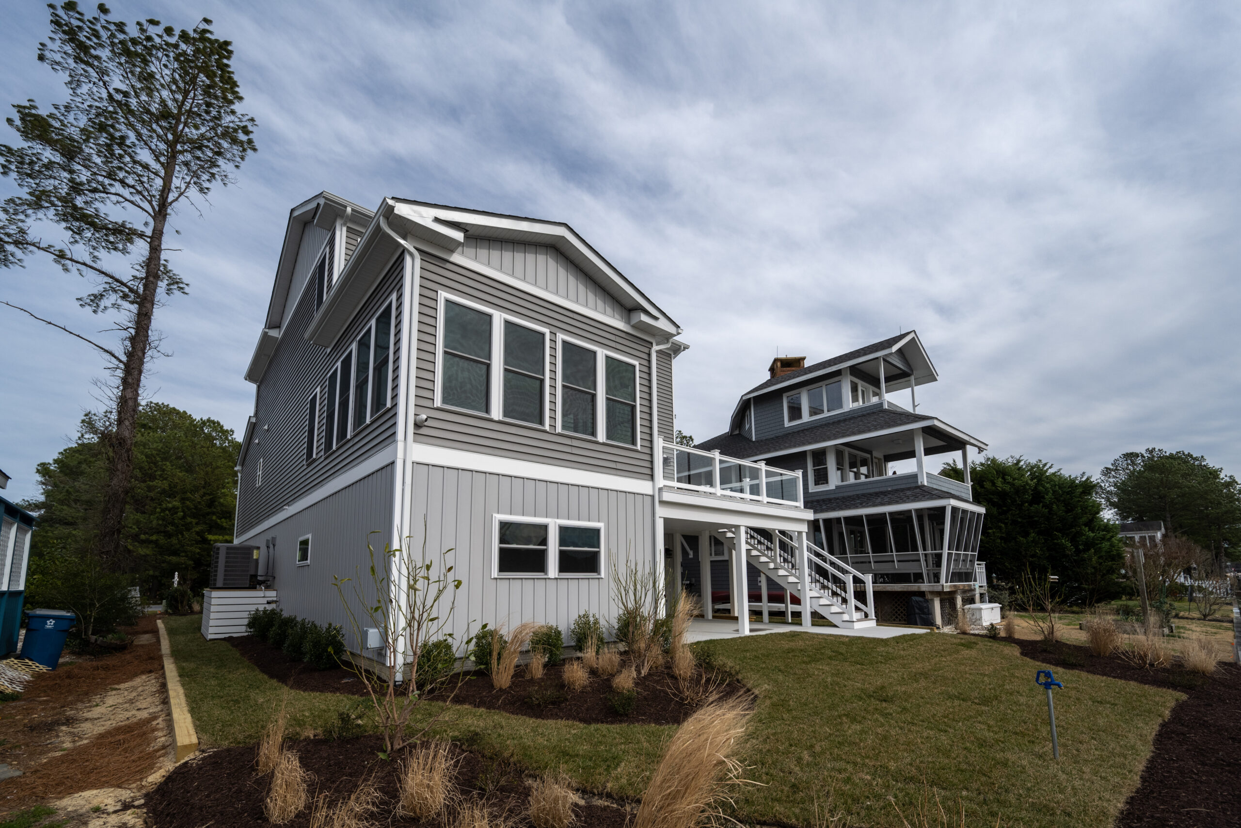a two story house sitting on top of a lush green field