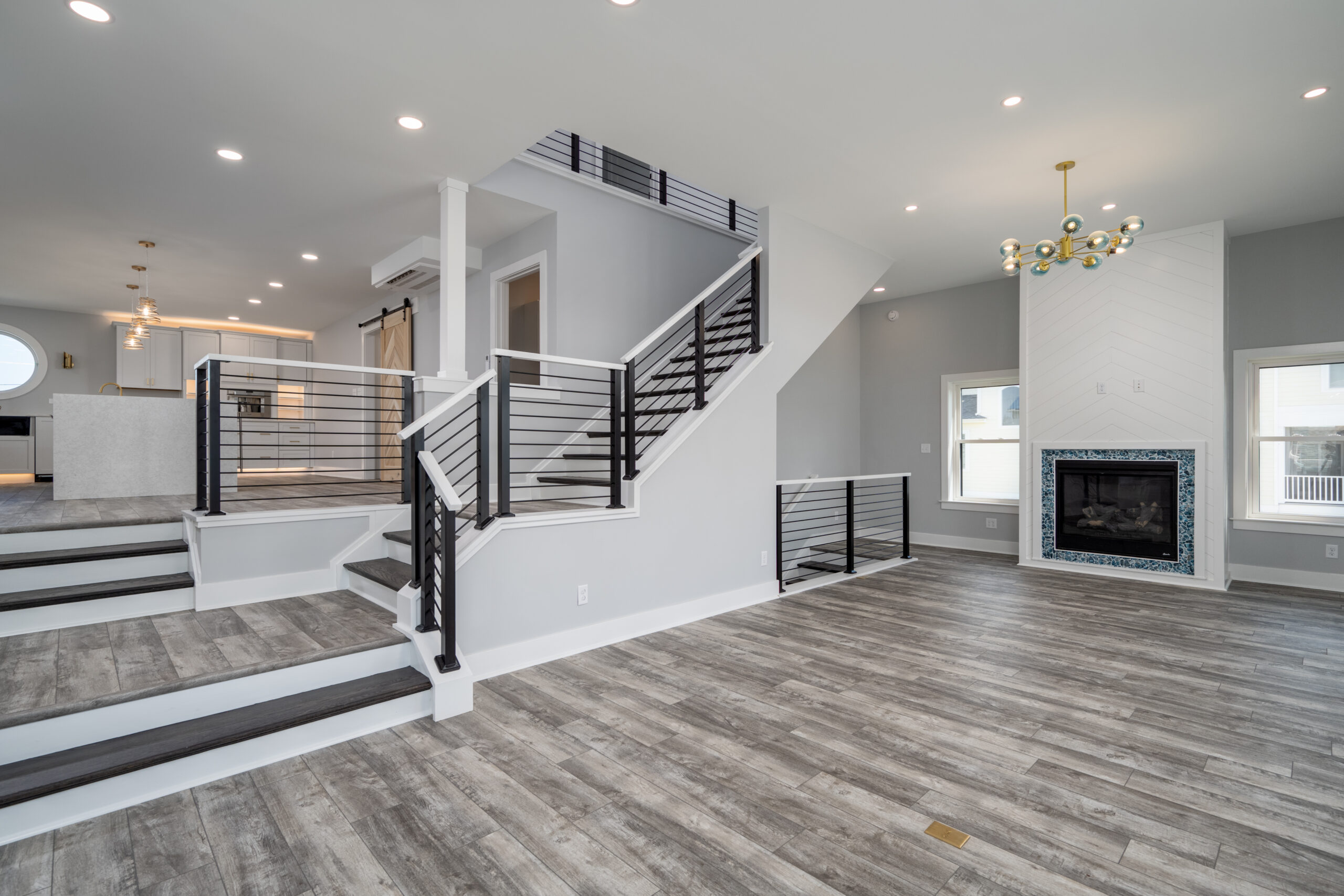 a large open floor plan with stairs and a fireplace