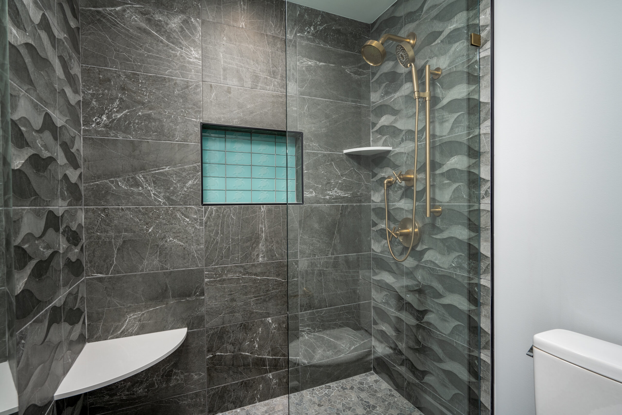 a bathroom with a walk in shower next to a toilet