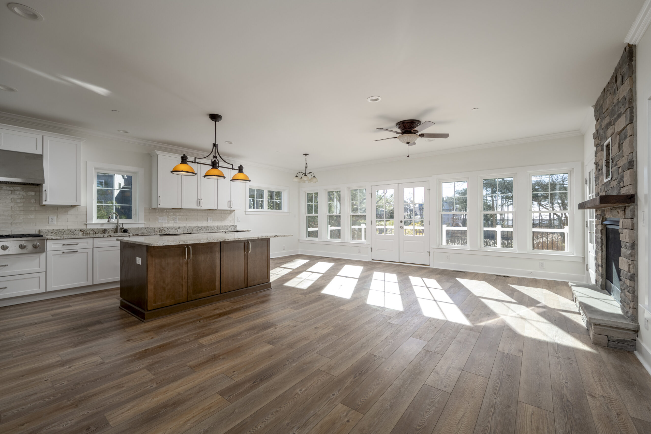 a large kitchen with white cabinets and wood floors