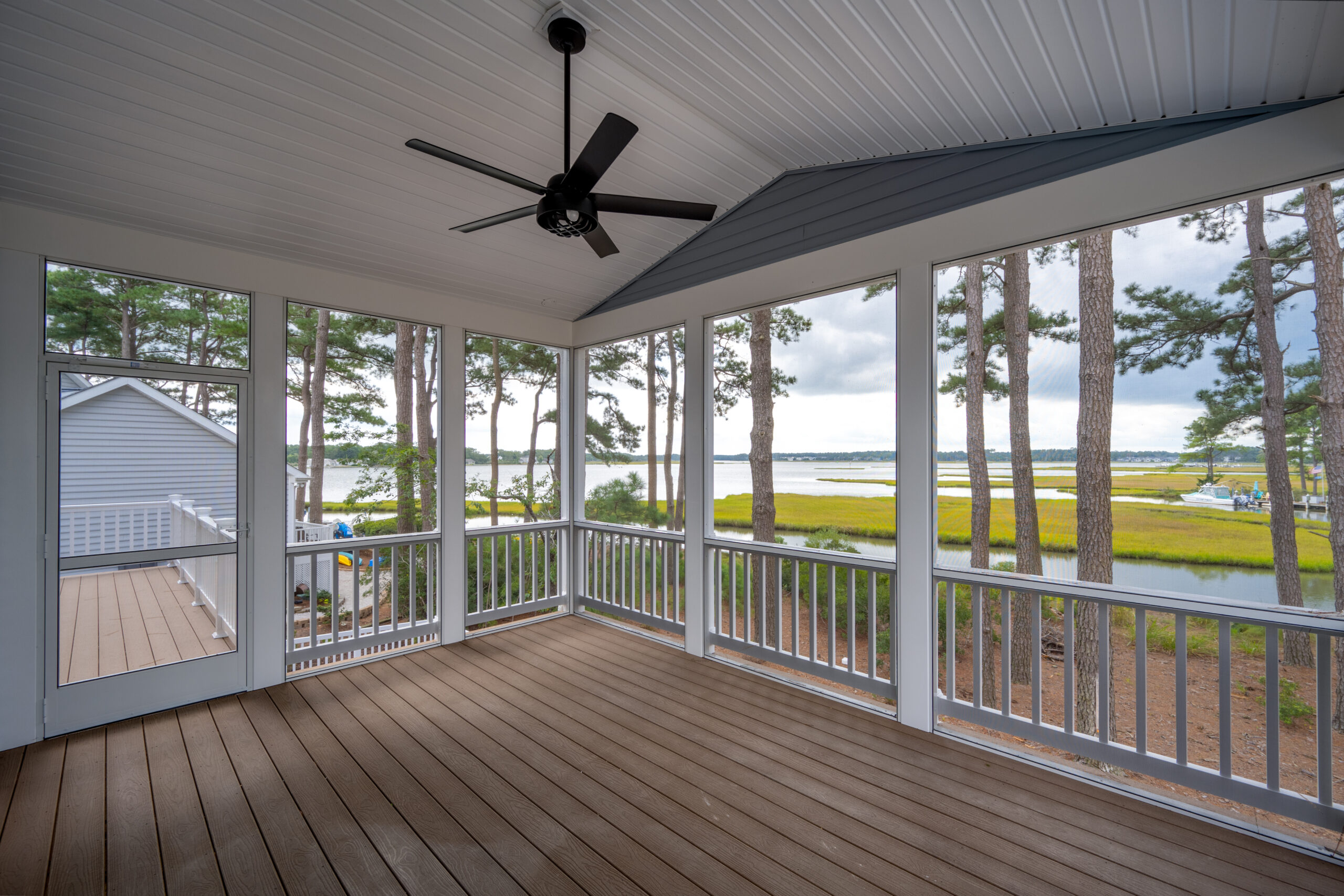 a large screened porch with a ceiling fan