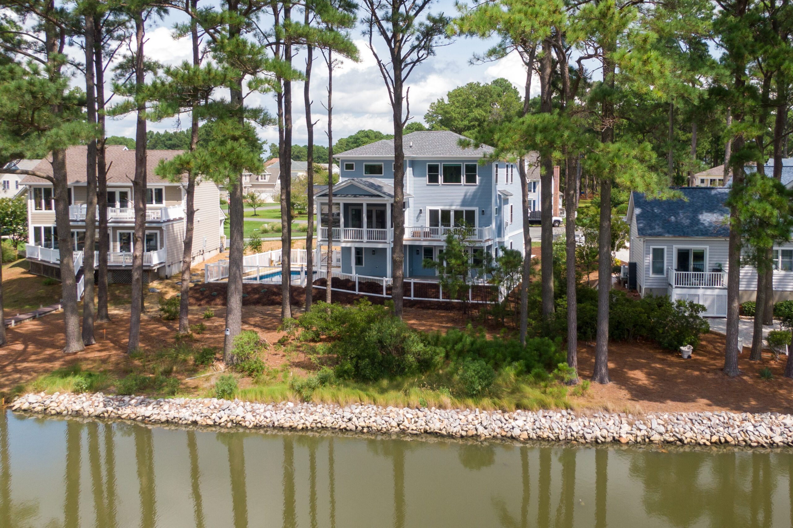 a group of houses sitting next to a body of water