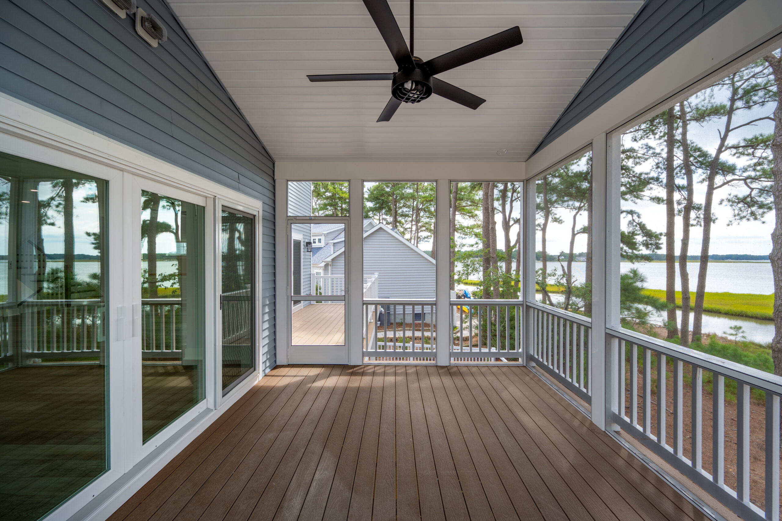 a porch with a ceiling fan and a view of the water