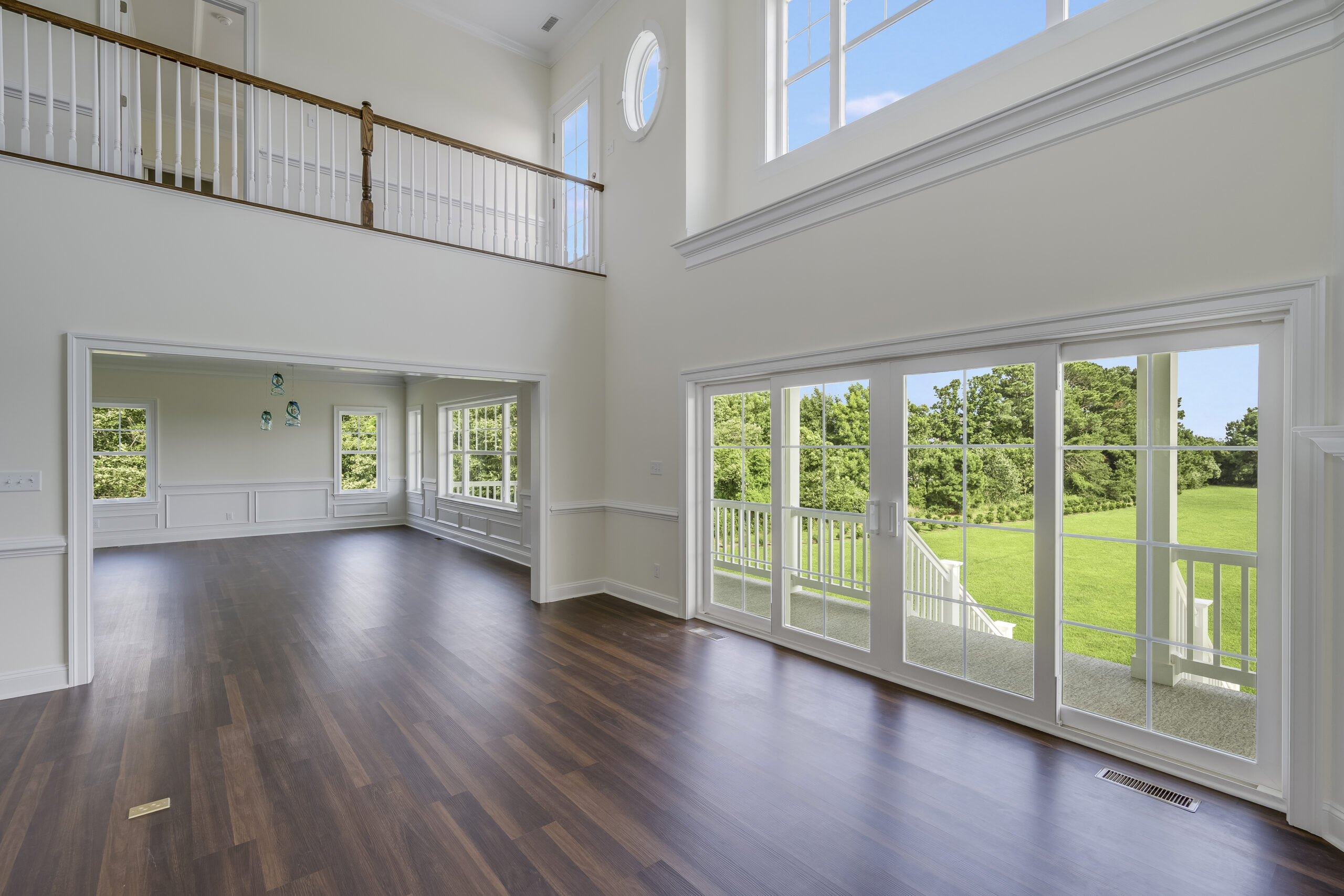 a large living room with wood floors and white walls