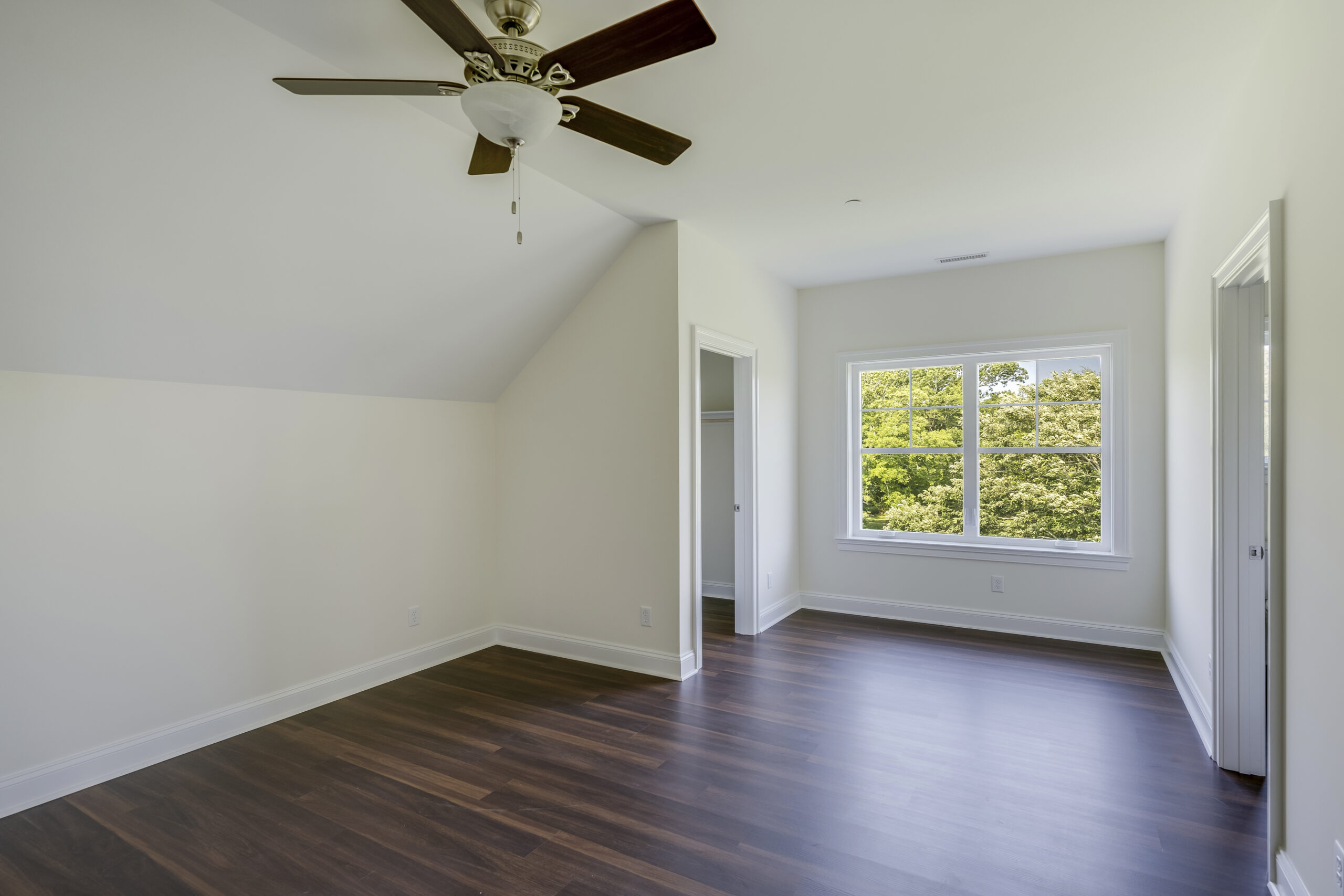 a large empty room with a ceiling fan