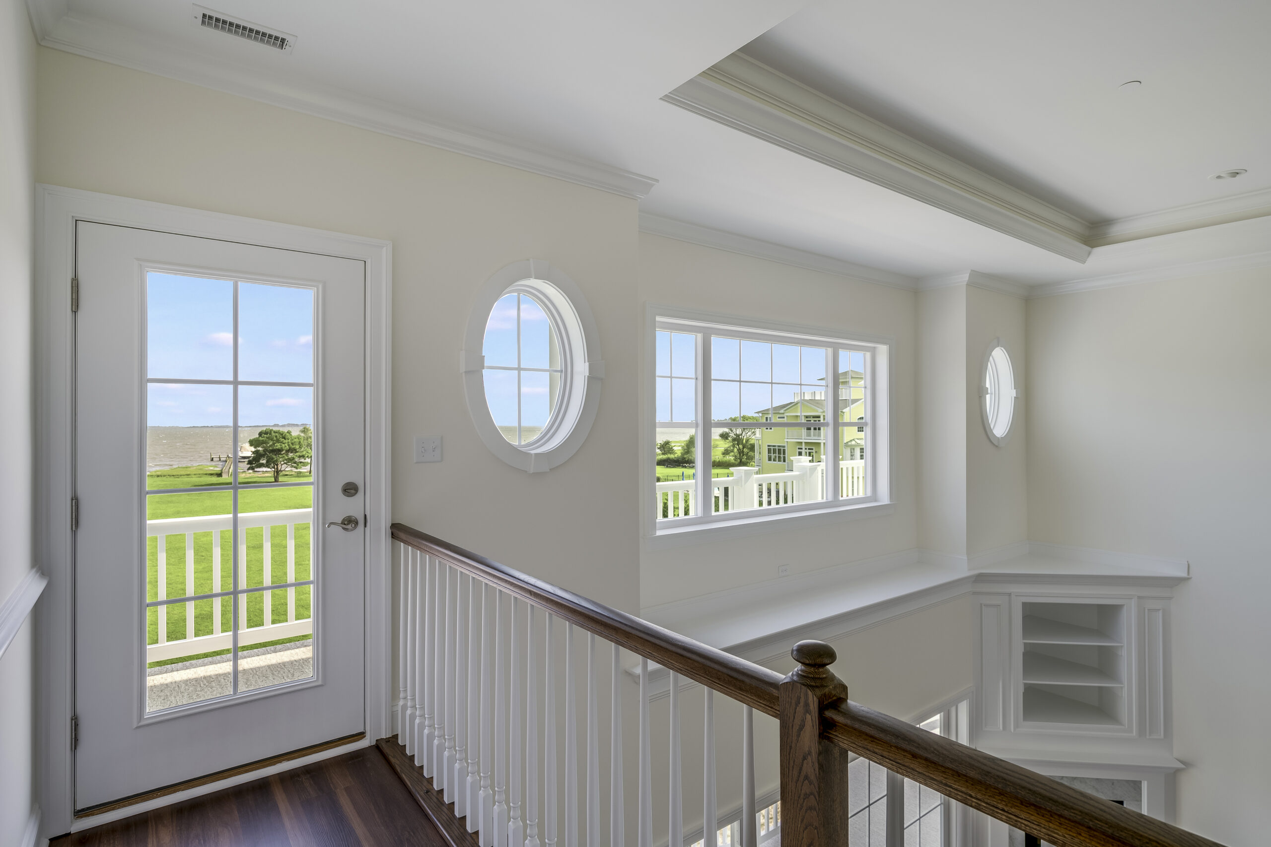 a white house with a wooden staircase leading to the front door