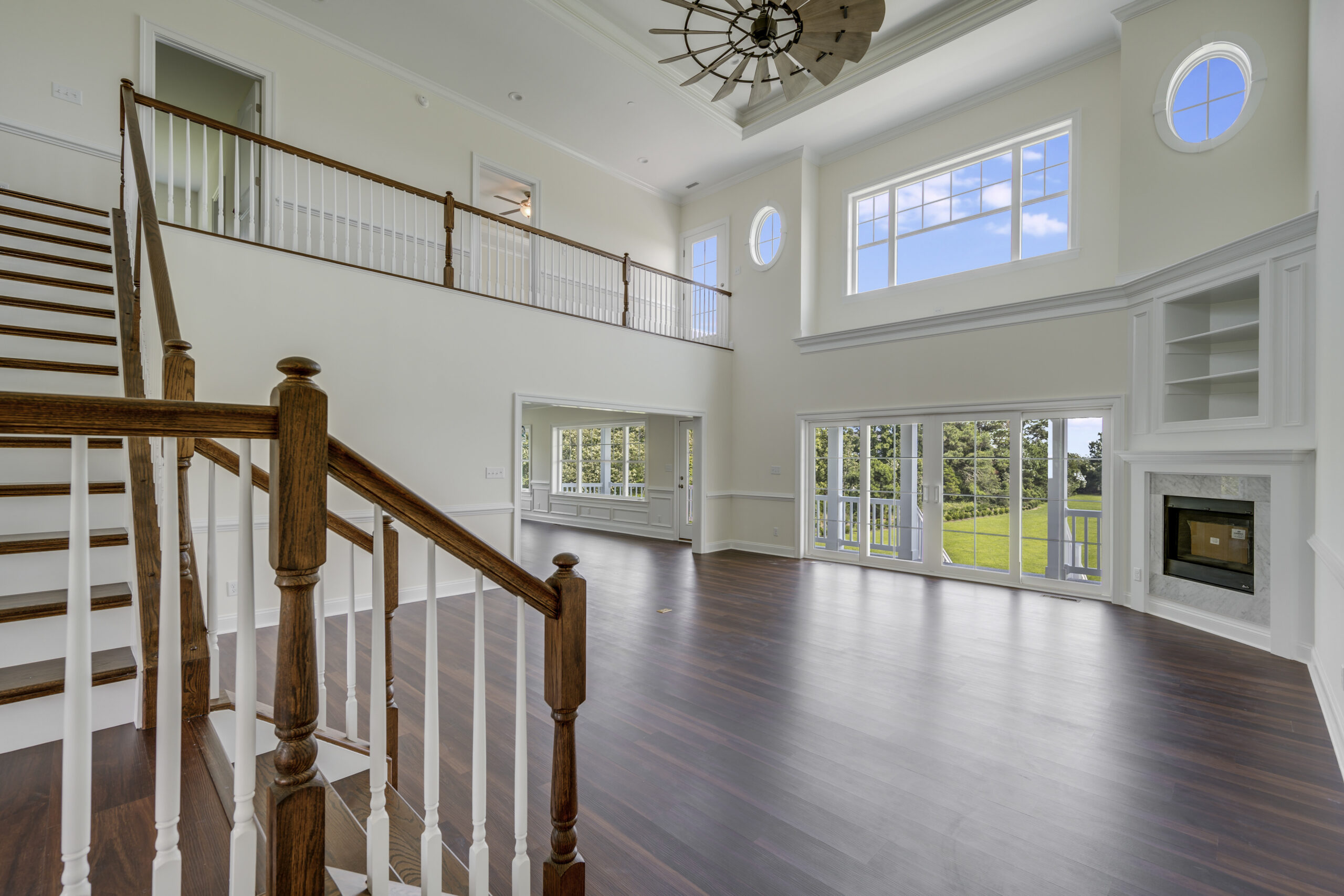 a large living room with hardwood floors and white walls
