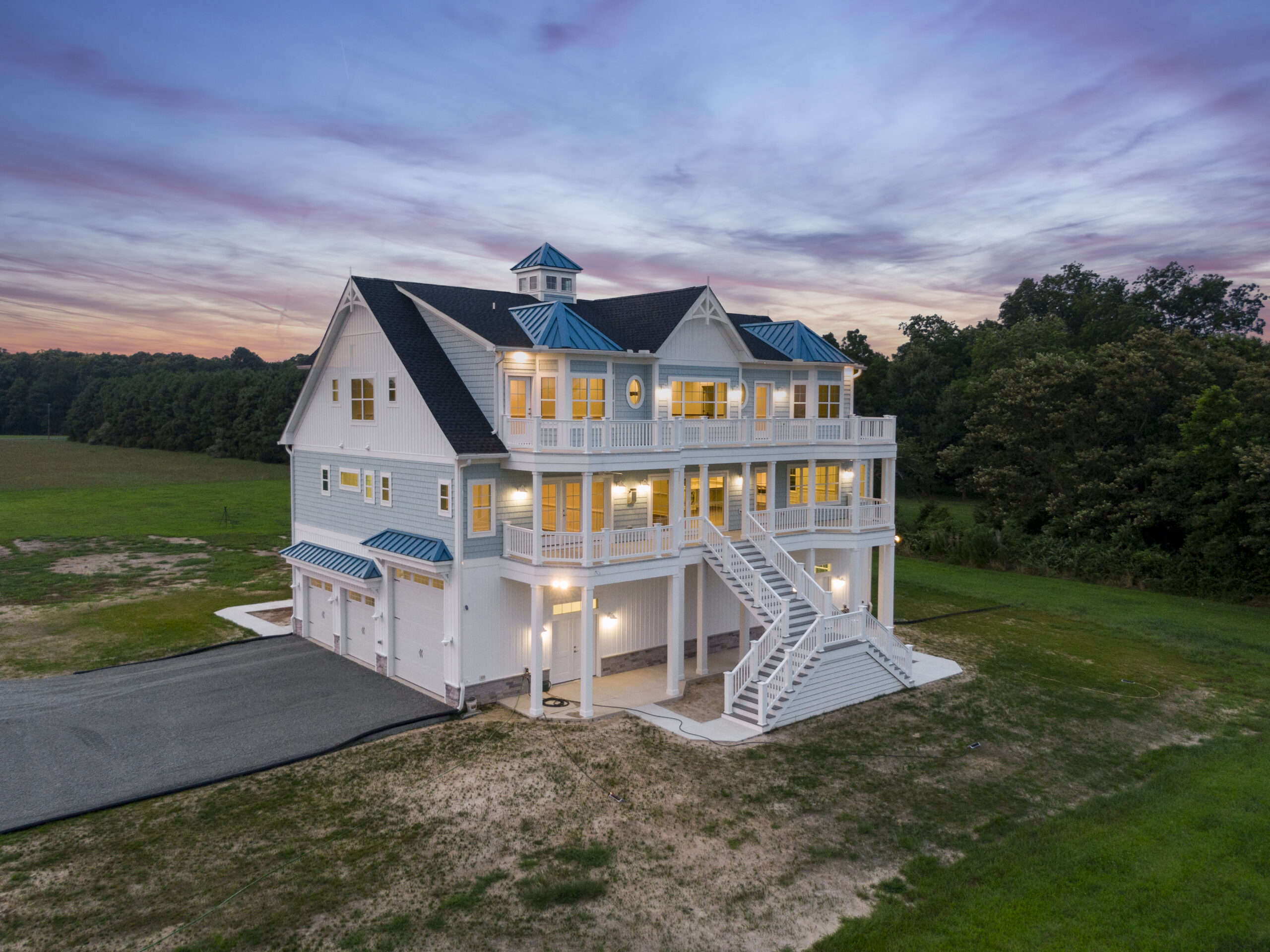 a large white house sitting on top of a lush green field