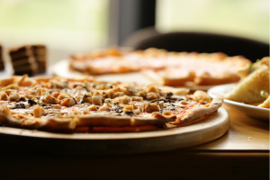 a pizza sitting on top of a wooden cutting board