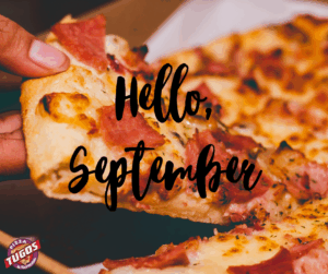 a person holding a slice of pizza in their hand