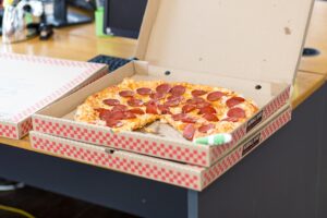 a pizza in a pizza box on a desk