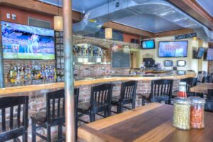 a restaurant with a bar and televisions on the wall