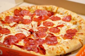 a pepperoni pizza sitting in a pizza box
