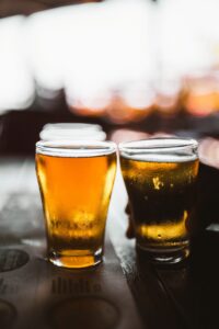 two glasses of beer sitting on top of a table