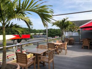 a patio with tables and chairs and a red umbrella