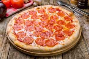 a pepperoni pizza sitting on top of a wooden table