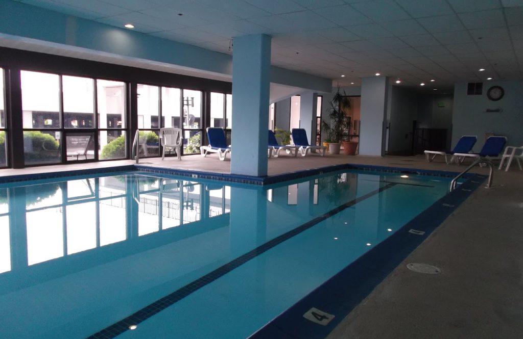 indoor pool, lounge chairs, and large window
