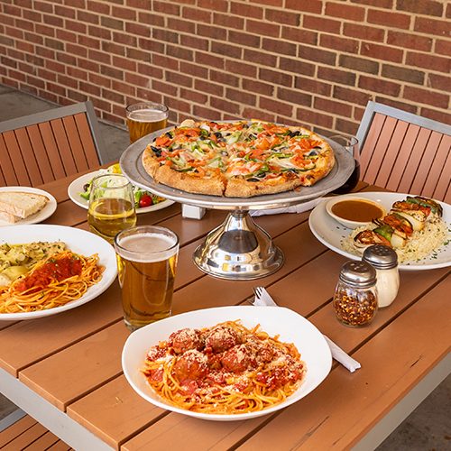 a wooden table topped with plates of food