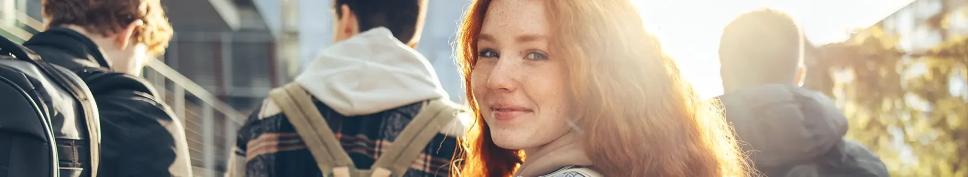 3 people looking away from the camera and one girl looking towards the camera