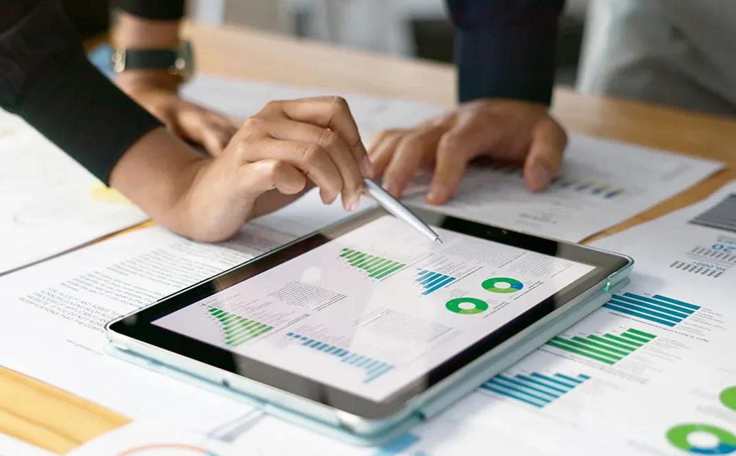 tablet and two people working on strategy performance