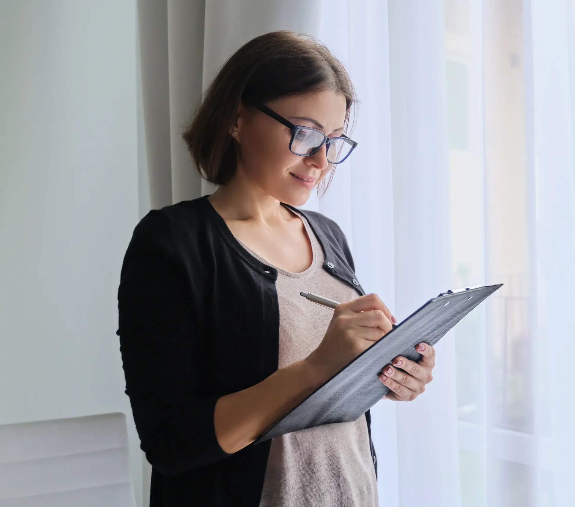 woman writing on a clip board