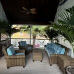 a porch with wicker furniture and a ceiling fan