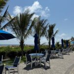 tables and chairs with umbrellas on a brick patio