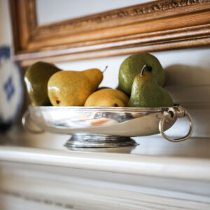 Pewter oval footed bowl with fruit in it