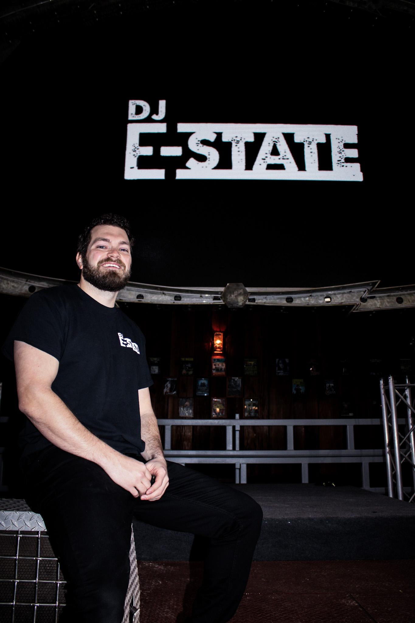 a man sitting on a ledge in front of a sign